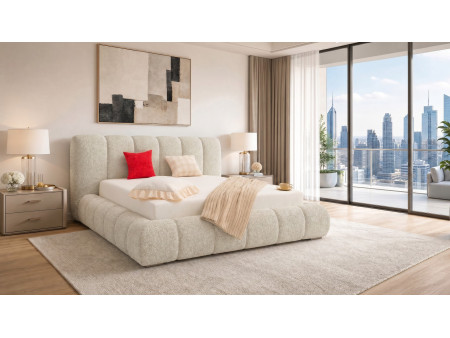 A side view of the beige Cloud Soft bed in a spacious bedroom with a large window and a view of the city.
